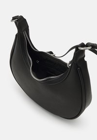 Sort halvlammeskindsformet håndtaske med sølv lynlås, justerbar rem og indvendig lynlåslomme, vist delvist åben i en vinkel.