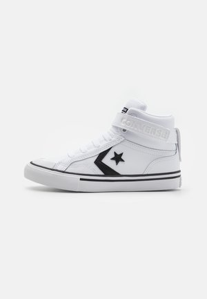 Biały wysoki sneaker Converse z czarnym logo gwiazdy, białymi sznurowadłami, paskiem na kostce z napisem "Converse" i białą gumową podeszwą z czarną obwódką.