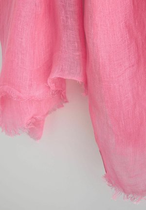 Lichtroze doorschijnende stof met een los geweven textuur en rafelige randen, hangend tegen een neutrale achtergrond.