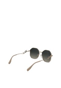 Aktogonal solbriller med gradient mørke linser, metallramme i lys beige, og unike krøllete detaljer på siden. Har slanke, matte stenger.
