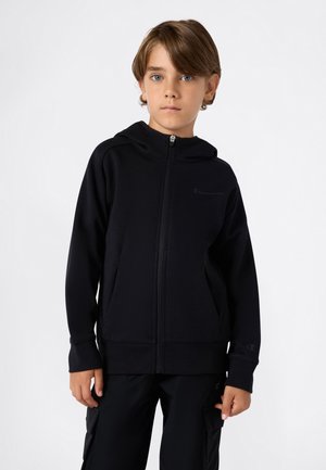 Felpa nera con zip realizzata in tessuto morbido, dotata di cappuccio, con un logo sul petto e tasche laterali. Abbinata a pantaloni neri.