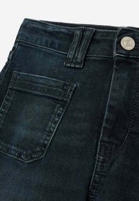 Donkerdenimjeans met een hoge taille, vijf-pocket ontwerp en een zilveren knoopsluiting, met subtiele texturen en een gladde stofafwerking.