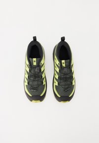 Lehké černo-neonově zelené běžecké boty s prodyšným svrškem z mřížky, gumovou podrážkou a elastickým systémem šněrování. Zesílená špička a poutko na patě.
