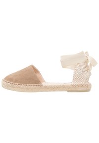 Espadrillas in suede color sabbia con punta tonda, tacco intrecciato e dettagli in nastro crema chiaro per la chiusura attorno alla caviglia. Suola in juta naturale.