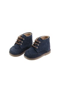 Botas de tobillo de ante azul marino con perforaciones decorativas y cordones marrones, con suela de goma marrón claro y detalles cosidos.