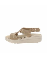 Sandali con zeppa di colore beige, caratterizzati da un design superiore perforato, cinturino regolabile con fibbia, soletta morbida e suola in gomma resistente.