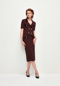 Robe à motifs rouges et noirs avec des manches courtes, design à double boutonnage, boutons dorés et style de jupe crayon ajustée.