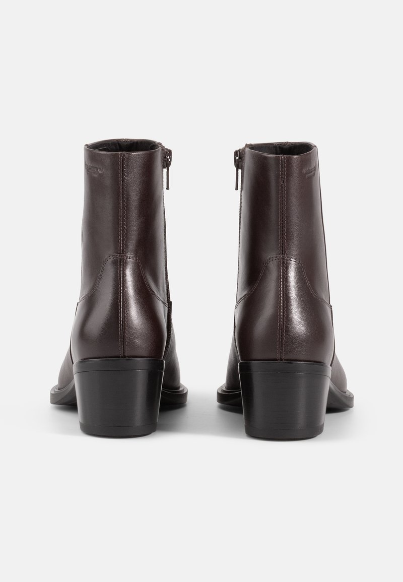 Brune læder ankelstøvler med en glat overflade, lynlås lukning og stablet hæl, der viser et strømlinet design og minimale syninger.