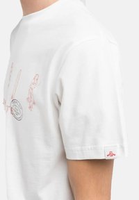 Witte katoenen T-shirt met roze grafische illustraties en een klein logo-patch op de mouw. Korte mouwen en ronde halslijn.