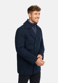 Marineblauer Wollmischung-Peacoat mit großen Revers, doppelter Knopfleiste und zwei Vorder Taschen. Glatte Textur und taillierte Passform.