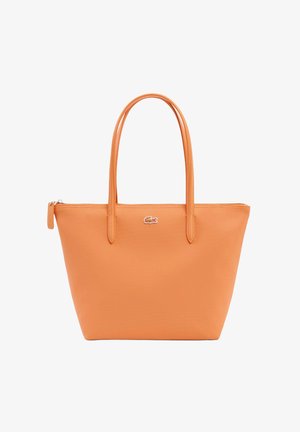 Oranje lederen shopper met dubbele handvatten, ritssluiting en klein zilveren krokodillenlogo in het midden aan de voorkant.