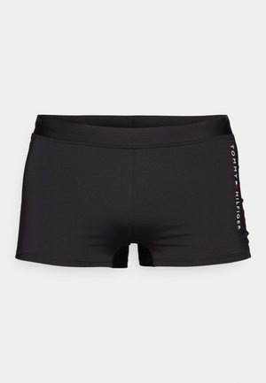 Schwarze Schwimmshorts aus glattem, dehnbarem Stoff. Mit einer mittelhohen Taille und kurzen Beinen; Logo in Weiß seitlich aufgedruckt.