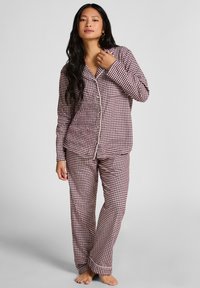 Rood-wit geblokt pyjama set, met een knoopjes blouse met kraag en lange mouwen, gecombineerd met bijpassende broek. Zachte stoftextuur.