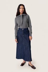 Szürke, hosszú ujjas blúz megkötős nyakkivágással, sötét farmer maxi szoknyával párosítva. Az outfit fekvő derekú, és elülső zsebekkel rendelkezik.
