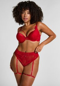 Rode kanten beha met doorzichtige mesh cups en verstelbare banden, in combinatie met een bijpassende hooggewaist kousenband met detailing en kousenclips.