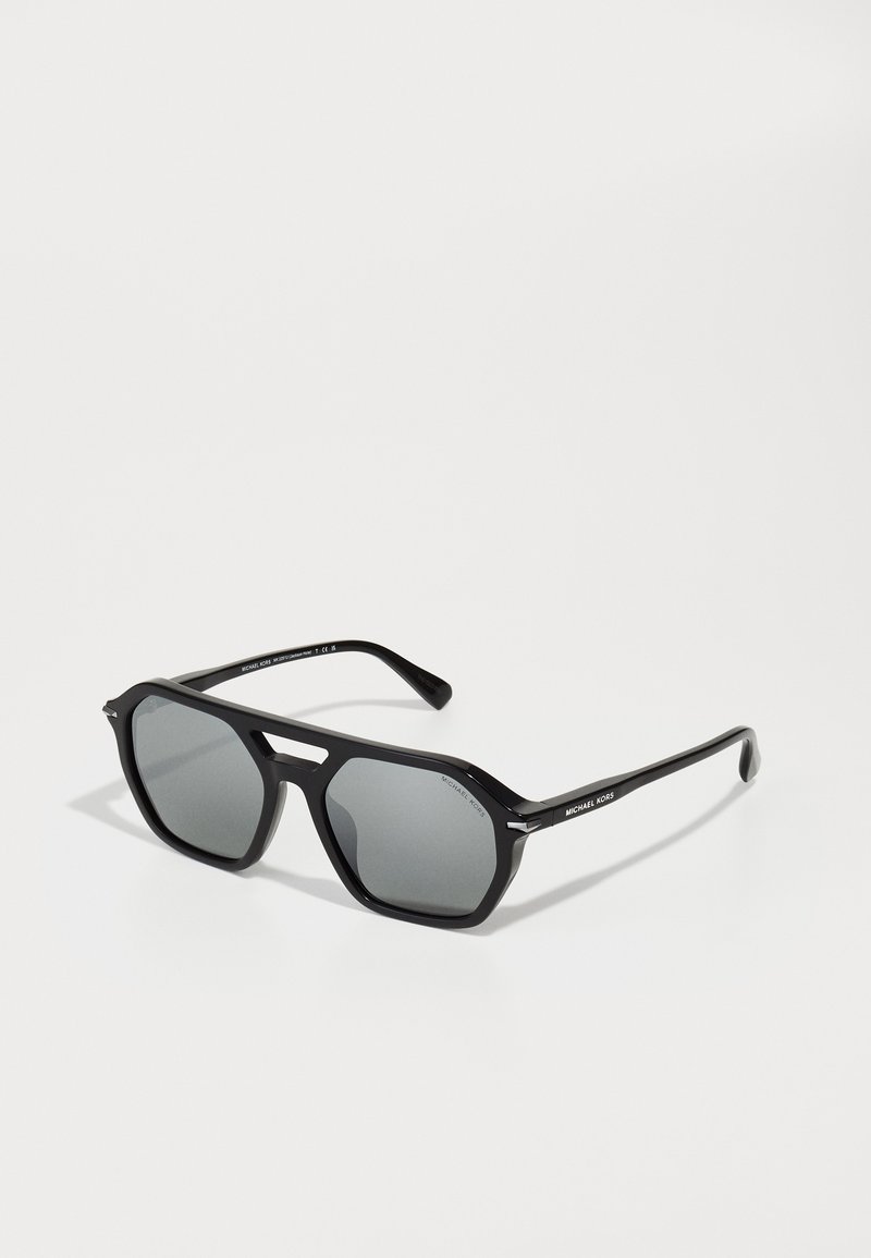 Ochelari de soare negri cu lentile hexagonale, lentile gri cu nuanțe, rame negre elegante și accente metalice lângă punte și temple.