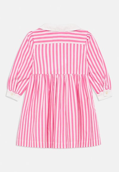 Ροζ και λευκό ριγέ φόρεμα με μακριά μανίκια, γιακά στο λαιμό και μανσέτες με κουμπιά. Φούστα με καμπάνα και πιέτες στη μέση.