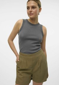 Grijze geribbelde tanktop met een ronde halslijn, gecombineerd met khaki hoge shorts met plooien en zijzakken.