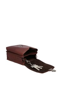Brown leather bag with a rectangular shape, featuring a flap closure and keychain inside. Suede lining visible inside.