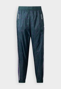 Windbreaker-Hosen in Dunkelgrün mit glatter Textur, ausgestattet mit einem subtilen Muster, weißen Seitestreifen und mit Reißverschlüssen versehenen Taschen. Elastischer Bund.