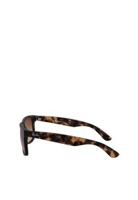 Occhiali da sole tartarugati con lenti scure, caratterizzati da una montatura più spessa e aste sottili, contrassegnati dal logo Ray-Ban sul lato interno.