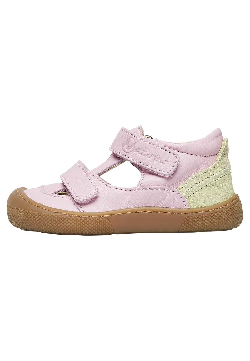 Pink leather shoe with Velcro straps, cut-out design, light green accents, and a textured rubber sole. Low-profile, rounded toe shape.