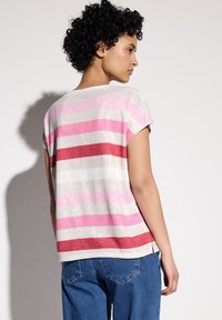 Camiseta de manga corta a rayas en tonos gris claro, rosa y rojo, con un corte relajado y un cuello redondeado.