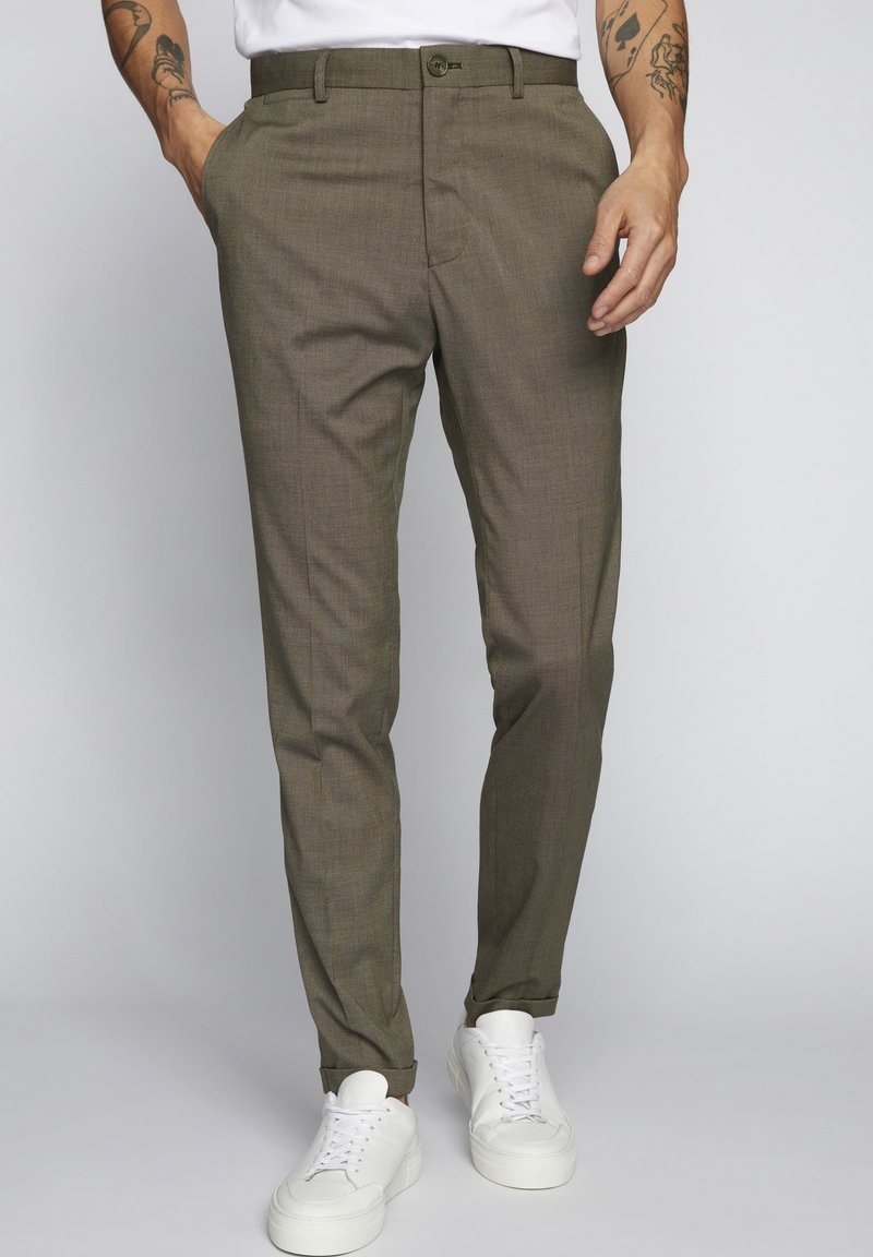 Bruna texturerade byxor med slim fit, som har en knappstängning och sidofickor, matchade med vita sneakers.