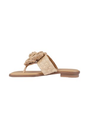 Sandale plate beige avec bride en tissu tressé et détail décoratif de fleur tressée sur une semelle couleur tan.