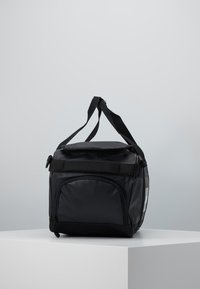 Bolsa de almuerzo aislante negra con forma rectangular, correa ajustable, bolsillo frontal y textura suave; cuenta con un cierre resistente y una correa.