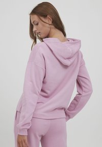 Rosa Sweatshirt mit Kapuze, langen Ärmeln und seitlichen Taschen. Hat eine lockere Passform und gerippte Bündchen. Glatte Textur, minimale Nähte.