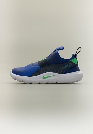 Baskets Nike slip-on bleues avec des accents verts, une semelle blanche, une languette au talon, et le texte "Just Do It" sur la bride latérale.