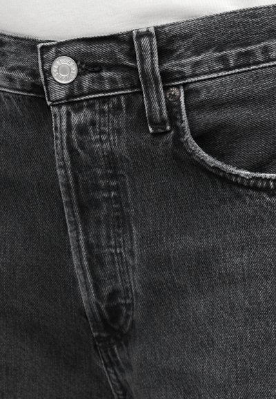 Σκούρα γκρι τζιν παντελόνια από ντένιμ με ομοιόμορφο χρώμα, παραδοσιακό σχεδιασμό με πέντε τσέπες, μεταλλικό κουμπί κλεισίματος και διακριτικές υφές.