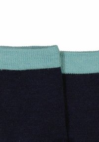 Marineblå sokker med en ribbet lys blå kant. Stoffet ser glat og strækbart ud, hvilket gør dem komfortable og godt passende.