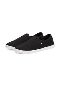Svarte canvas slip-on sko med elastiske sidde aksenter og hvit gummisåle. Har en liten logo detaljer på utsiden.