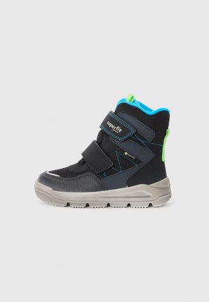 Bottes de randonnée pour enfants noires et grises avec deux bandes velcro réglables, des accents bleus, un tissu texturé et une semelle grise robuste.