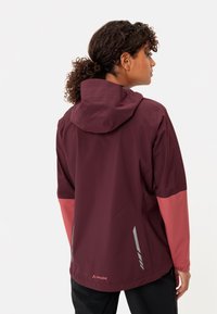 Giacca da esterno bordeaux e rosa con cappuccio, dotata di dettagli riflettenti, design elegante e texture liscia. Logo visibile all'orlo.