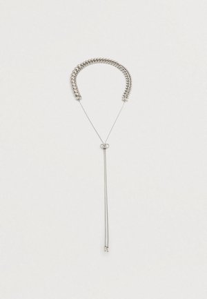 Ασημί κόσμημα λαιμού με δύο διαφορετικά στυλ αλυσίδας συνδεδεμένα με έναν ρυθμιζόμενο κούμπωμα και δύο κρέμες αλυσίδας να κρέμονται σε ουδέτερο φόντο.