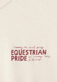 Light beige fabric featuring red text. The words "Honoring the equinal beauty" and "EQUESTRIAN PRIDE" are prominently displayed.