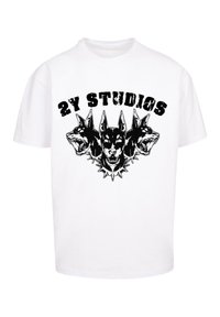 Fehér pamut póló, amelyen fekete grafikai tervezés látható három kutyafejjel, a műalkotás felett a "2Y STUDIOS" felirattal. Kerek nyak, rövid ujjú.