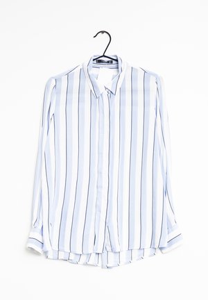 Overhemd met lange mouwen en knopen, met verticale witte, lichtblauwe en zwarte strepen, hangend aan een zwarte hanger.