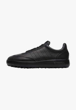 Czarne skórzane sneakersy o gładkim wykończeniu, z poziomymi przeszyciami i teksturowaną gumową podeszwą zapewniającą przyczepność.