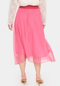 Gonna midi rosa fluida con una texture trasparente, caratterizzata da una vita arricciata e un morbido drappeggio, che crea un leggero movimento ed un effetto di stratificazione.
