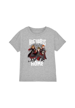 Hellgraues T-Shirt mit drei jungen Zauberern in Roben, die Zauber wirken, mit Schloss Hogwarts im Hintergrund und dem Text „Hogwarts ist mein Zuhause.“