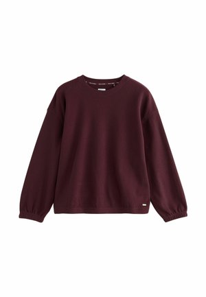 Burgunderfärgad långärmad tröja i ribbat material, med rund halsringning och elastiska ärmslut, prydd med en liten logotyp.