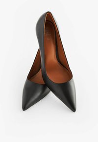 Scarpe con tacco alto in pelle nera con design a punta. Texture liscia, interno con rivestimento in pelle marrone. Silhouette classica senza accessori.