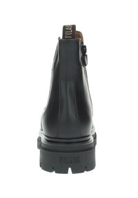 Botas de cuero negro hasta el tobillo con suela gruesa, que cuentan con un cierre lateral y una tira de tela para tirar. Costuras decorativas a lo largo de los bordes.
