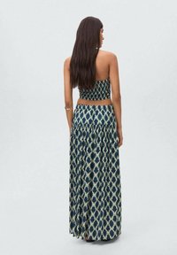 Two-piece outfit featuring a navy and cream pattern. The top is fitted, and the long skirt has a tiered design with a flared hem.