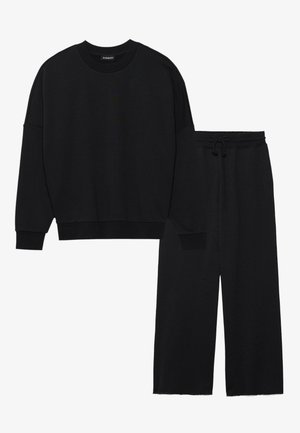 Black sweatshirt and matching pants set, made of soft material, featuring a relaxed fit, crew neckline, and wide-leg design with drawstring waist.