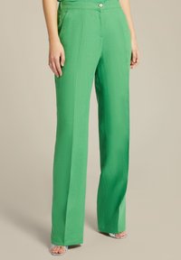 Pantaloni verdi a gamba larga realizzati in tessuto testurizzato con vita alta, dotati di una chiusura con bottone a vista e tasche laterali.